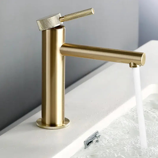 The allfixture Solid Brass Single Handle Bathroom Sink Faucet, featuring a modern gold-toned finish, cylindrical base, and sleek side-mounted handle, is shown. Water flows steadily from the spout into a white basin filled with water, creating ripples. The background is plain and neutral.