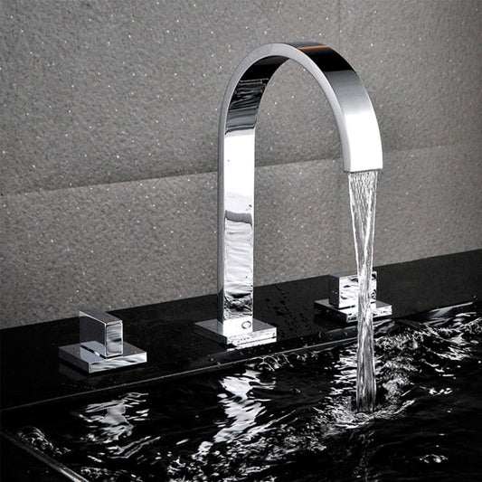 A sleek, modern Double Handle Deck Mounted Bathroom Sink Faucet from AllFixture with a high arch design is flowing water into a dark sink. The chrome fixture, reminiscent of a stylish shower head with its reflective finish, is set against a textured gray wall. The clear sink water ripples gracefully under the constant stream from the faucet.