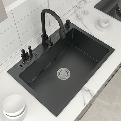 This image showcases a modern kitchen sink setup featuring the AllFixture 304 Stainless Steel Multifunction Kitchen Sink With Knife Holder. It includes a matte black kitchen sink faucet and a matching large rectangular basin. The countertop integrates soap dispensers and cup holders, all installed in a marble surface and flanked by white ceramic dishes.