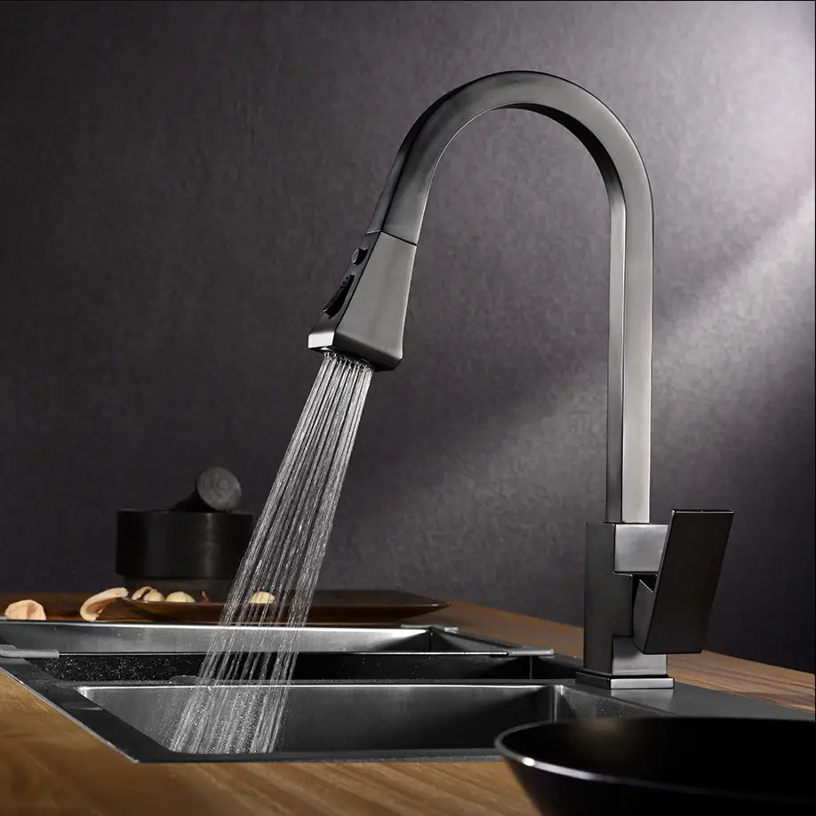 A modern Wanfan™ Pull Out Kitchen Faucet by allfixture, with a sleek black finish, mounted over a stainless steel sink, dispenses water in a steady stream. The background features a dark wall, light wooden countertop, and kitchen items including a bowl and pot—perfectly complementing any bathroom faucets or shower head for cohesive home decor.