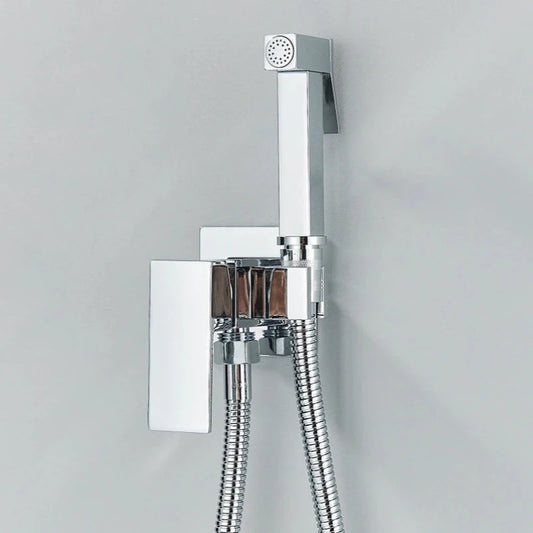 A sleek, modern chrome Wall Mounted Toilet Sprayer Bidet Faucet from Morsale.com is installed beside a stylish bathroom sink faucet. The set includes a handheld sprayer with a rectangular handle and a matching rectangular wall bracket. Two flexible metal hoses are attached to the bottom of the bracket, resting against the wall.