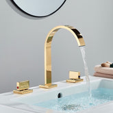 A modern bathroom sink features the Double Handle Deck Mounted Bathroom Faucet by AllFixture in polished gold, with a high-arching spout that gracefully dispenses water into the basin. The faucet has two square-shaped handles; one bears a red indicator for hot water, and the other displays a blue indicator for cold water. In the background, a round mirror can be seen.