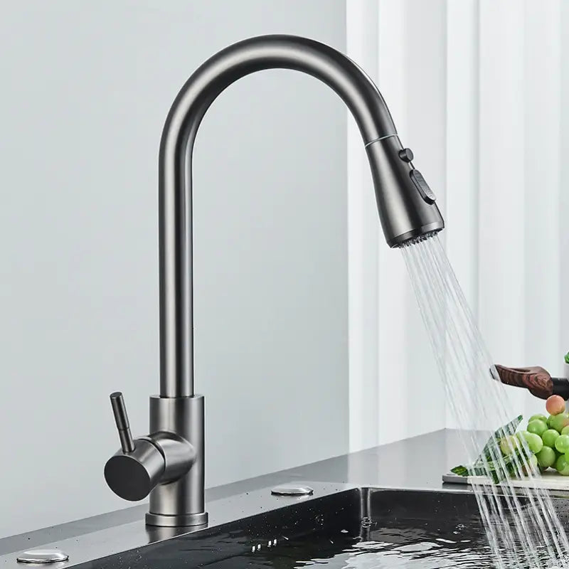 The Rozin Multifunction Pull Out Spout Kitchen Faucet, featuring a high-arc design and a matte black finish, is spraying water into a stainless steel sink. The faucet has a single lever handle on the side and comes with a pull-down spray head.