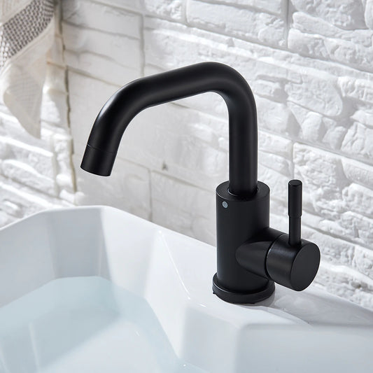 The Wasser™ Deck Mounted Single Handle Bathroom Sink Faucet by MyQualife, featuring a sleek, curved design in modern black, is installed on a white sink. Behind the sink is a white, textured brick wall, with a white towel adorned with a beige stripe hanging nearby.
