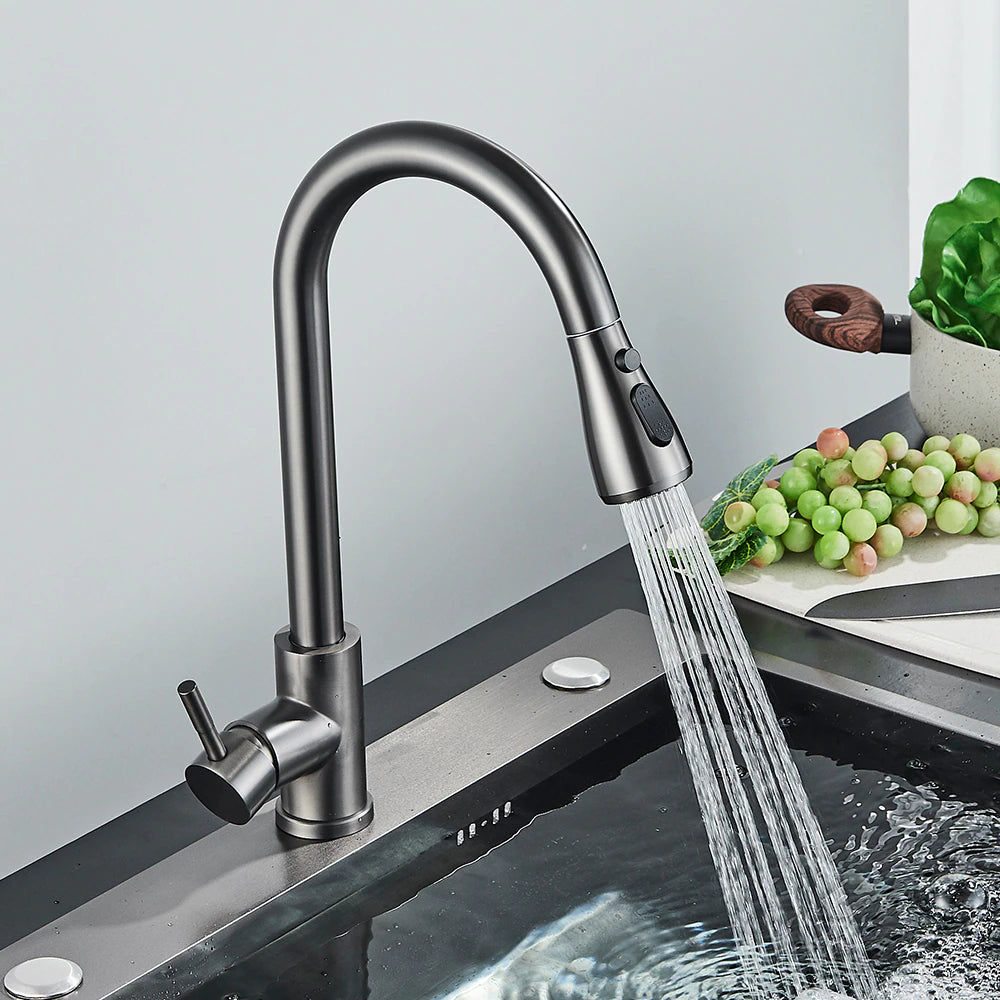 The Rozin Multifunction Pull Out Spout Kitchen Faucet, featuring a high-arc design and a matte black finish, is spraying water into a stainless steel sink. The faucet has a single lever handle on the side and comes with a pull-down spray head.