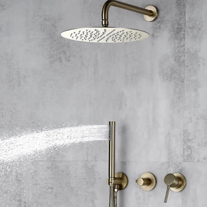 A modern minimalist shower setup features the Wasser™ Brushed Gold Shower System with Handheld Sprayer by Morsale.com, showcasing a large, round, wall-mounted rain showerhead and a sleek handheld shower spray emitting water. The brushed gold fixtures, including complementary bathroom faucets, accentuate the textured gray tile wall. Two control knobs are visible below.