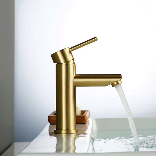 The Wasser™ Brushed Gold Solid Brass Bathroom Faucet by allfixture, featuring a sleek, modern design with a single lever handle, is positioned over a white sink with water flowing from the spout. In the background, a soap dish with a bar of soap adorns the countertop. This elegant faucet seamlessly complements other bathroom faucets and fixtures in your home.