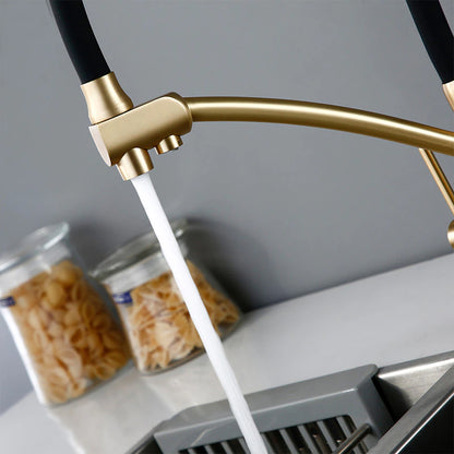 A person is using the Wasser™ Solid Brass Kitchen Faucet With Filtered Water Tap by allfixture to wash green apples in a sink. The countertop features a cutting board with a tomato, and jars of pasta are visible in the background. The overall kitchen decor is minimalist and contemporary, highlighting the modern design of the sleek gold and black kitchen faucet.